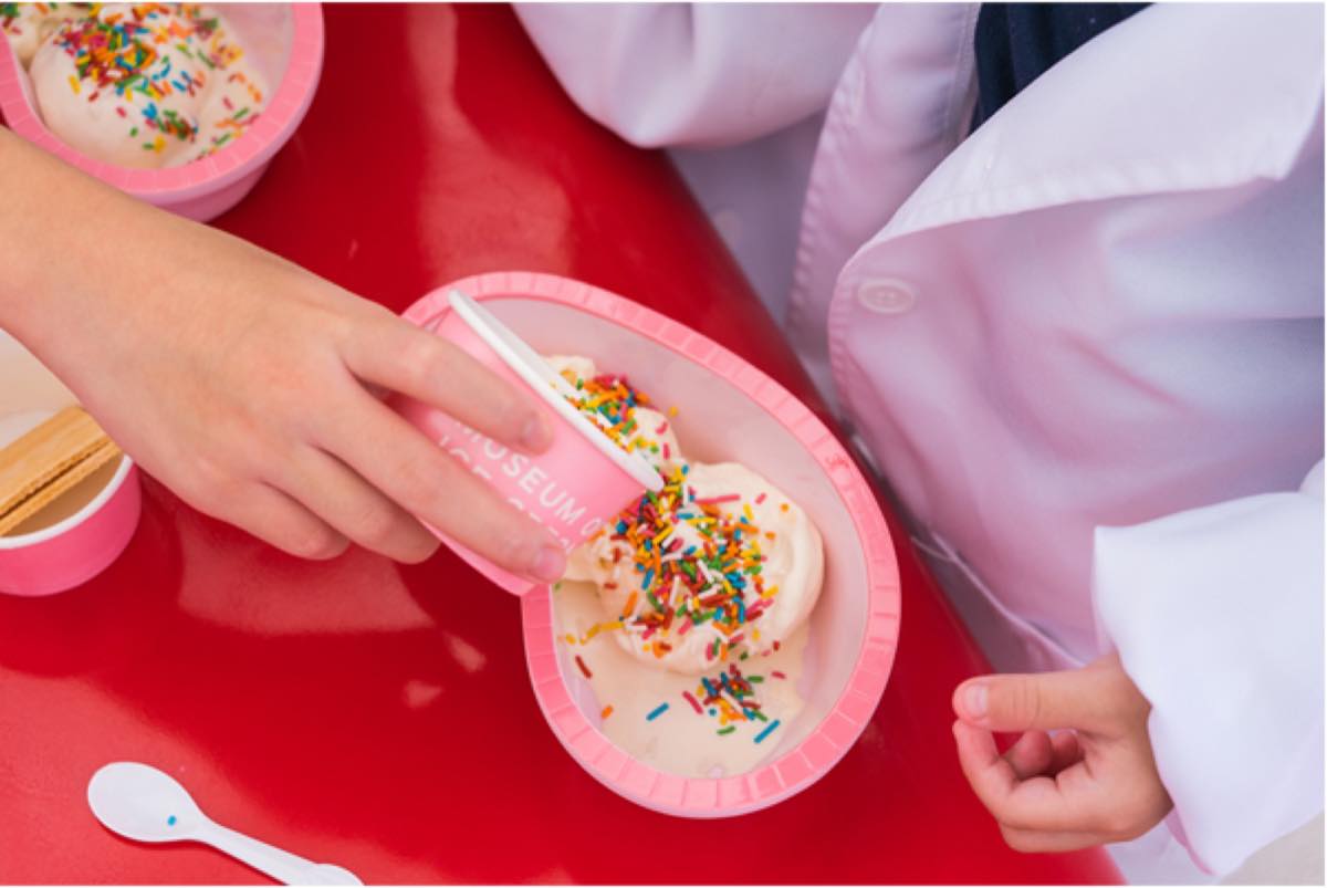 A young participant scooping and topping their own ice cream at Museum of Ice Cream Singapore