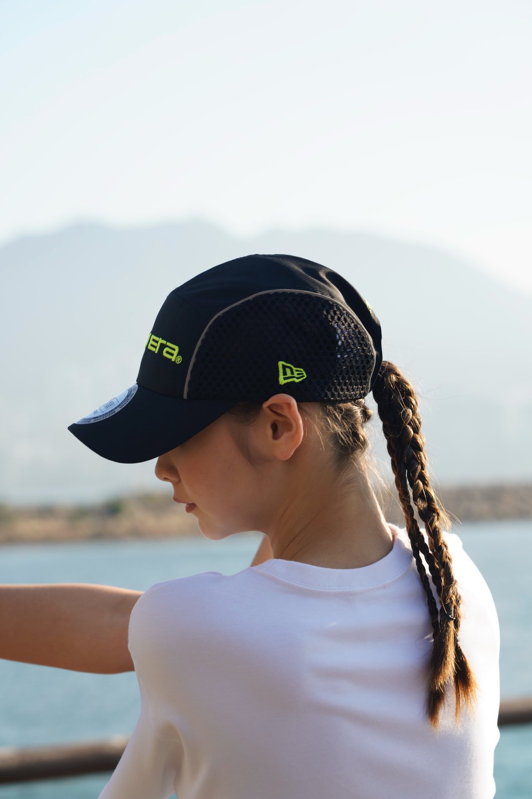 A runner wearing the black NEW ERA RUNNER Reflective cap with reflective piping and mesh side panels