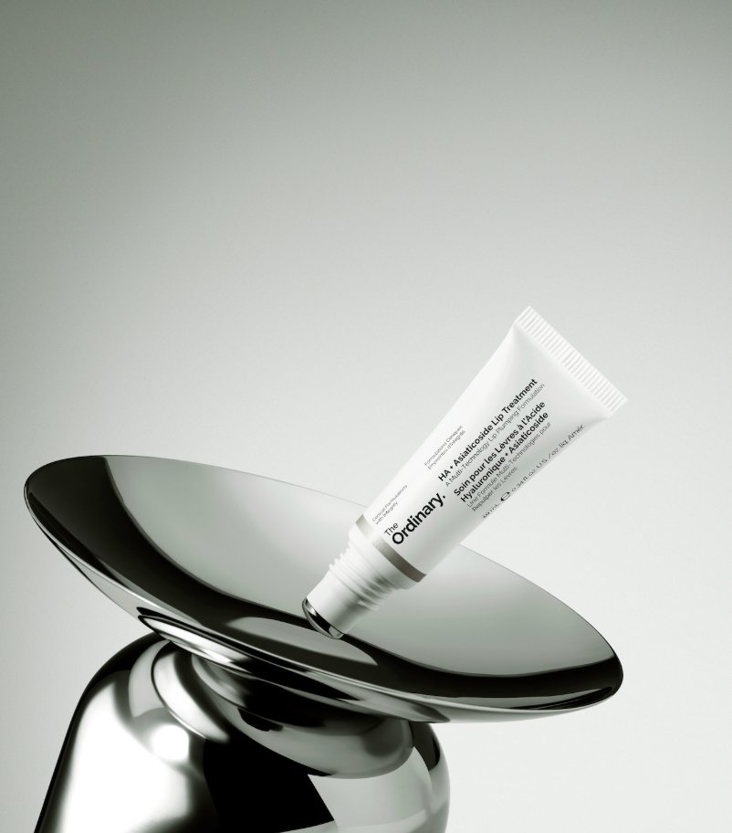 The Ordinary HA + Asiaticoside Lip Treatment 10ml tube resting on a chrome pedestal